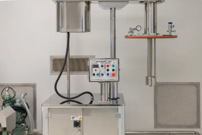 Stainless steel industrial machine with control panel in a clean white room.